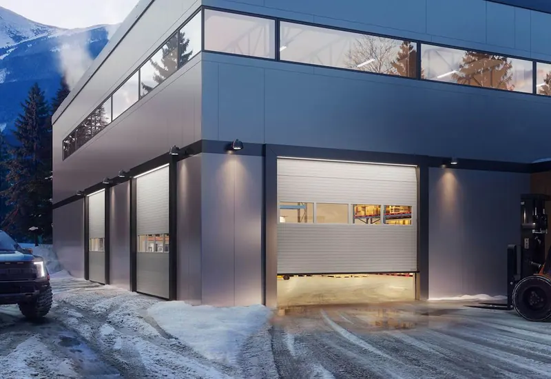 Commercial building with Hörmann full-view sectional door lit at dusk